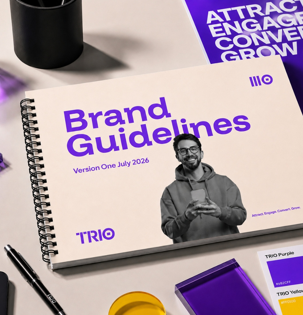 The TRIO Brand Guidelines book on the studio desk with the brand colour swatches